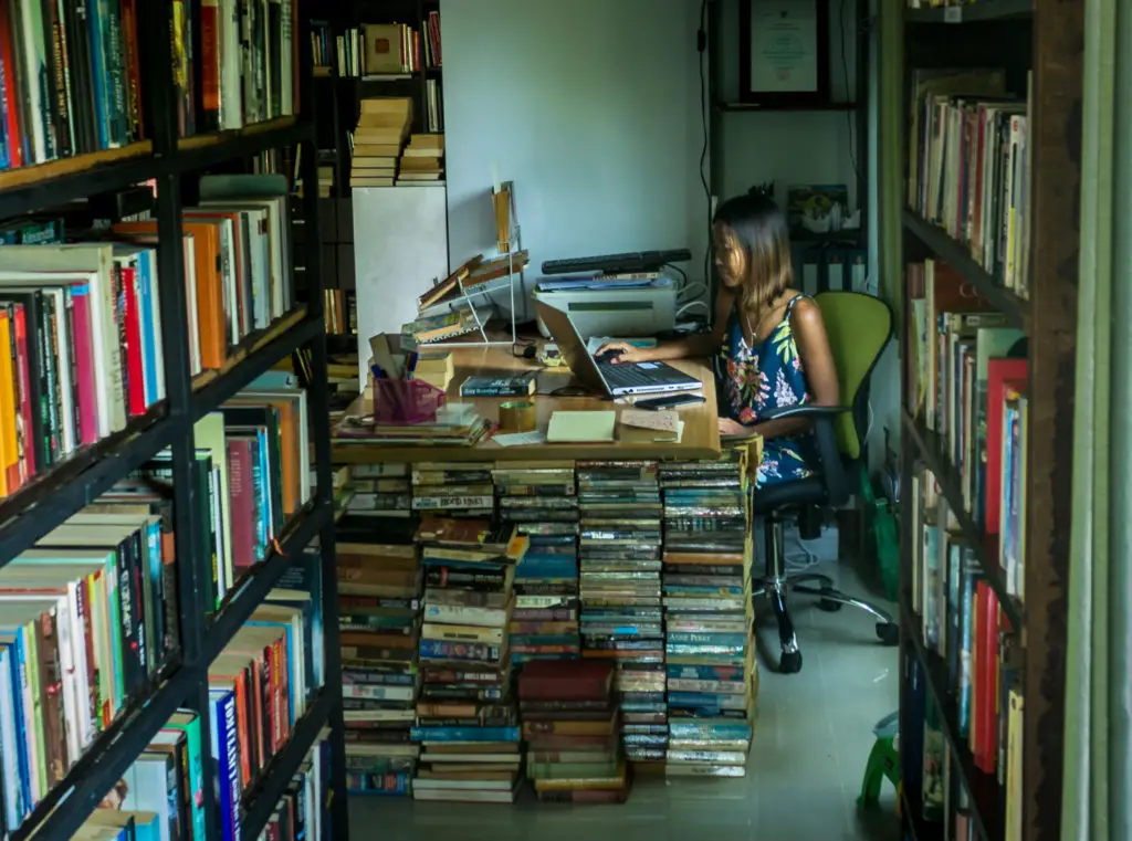 A DIY desk in a book shop engulfed by books
