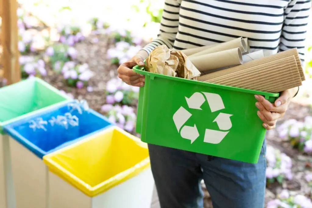a woman holding a bunch of recyclable materials