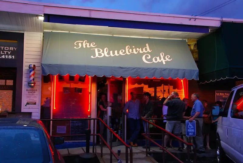 people queing outside cafe at night in secluded lights