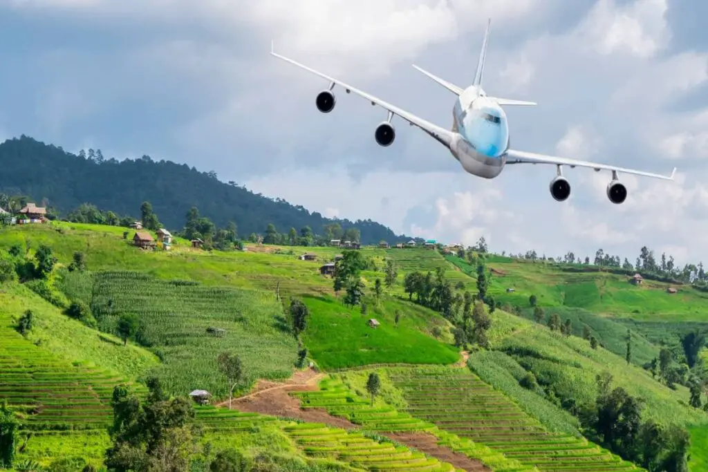 Airplane fly over the beautiful landscape of green paddy field
