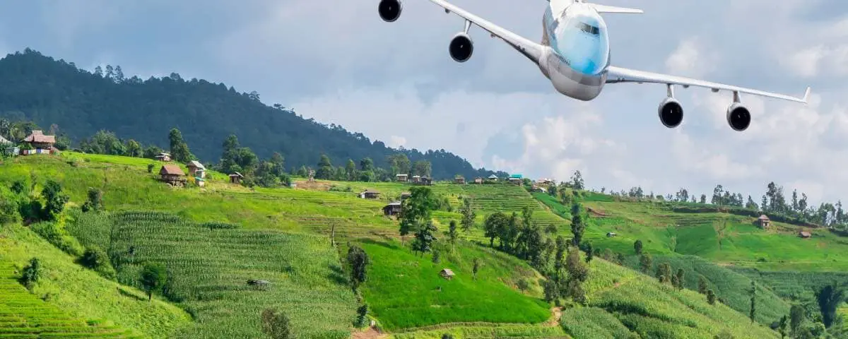 Airplane fly over the beautiful landscape of green paddy field