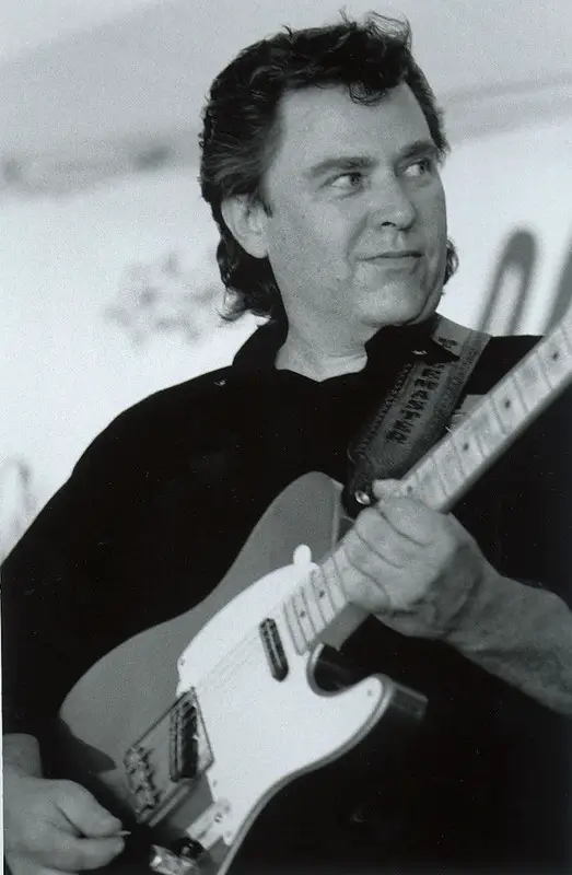 Close up of Danny Gatton holding guitar smiling
