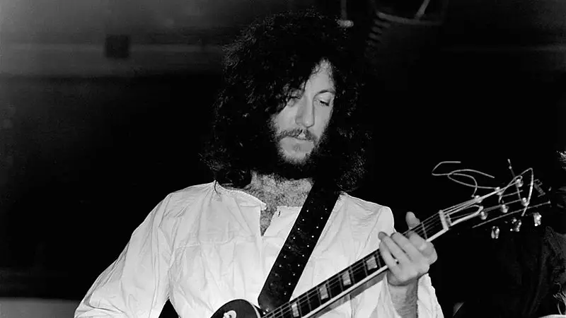 Black and white photo of Peter Green playing guitar in live performance