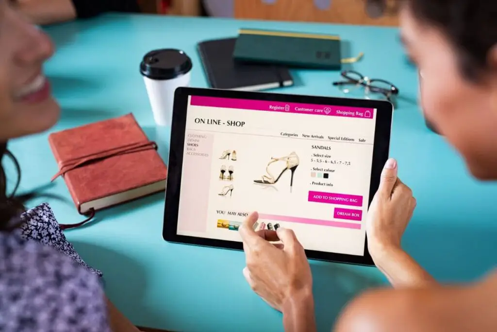 Closeup of woman doing online shopping on digital tablet at cafeteria