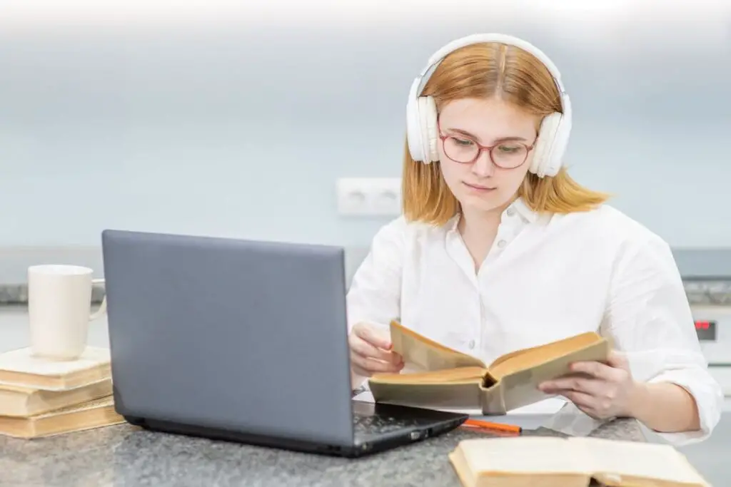 Young girl wearing headphones studying online with a laptop