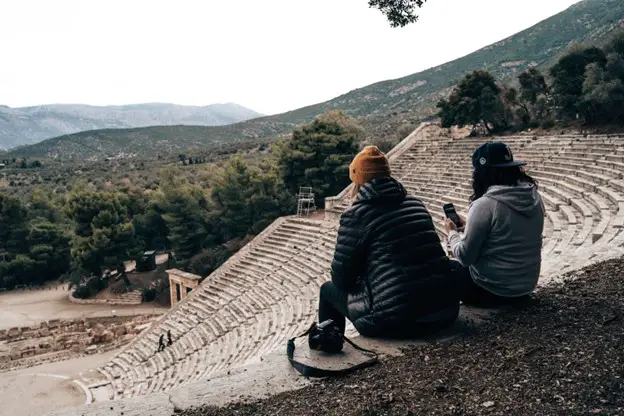 2 women-sitting-in-outdoor-amphitheatre-theatre looking over distant hills