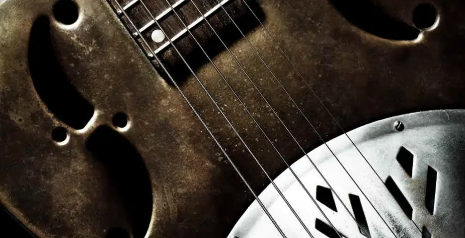 close up photo of a steel gutar - Image source: https://www.guitarhabits.com/8-reasons-why-learning-the-blues-is-so-important/