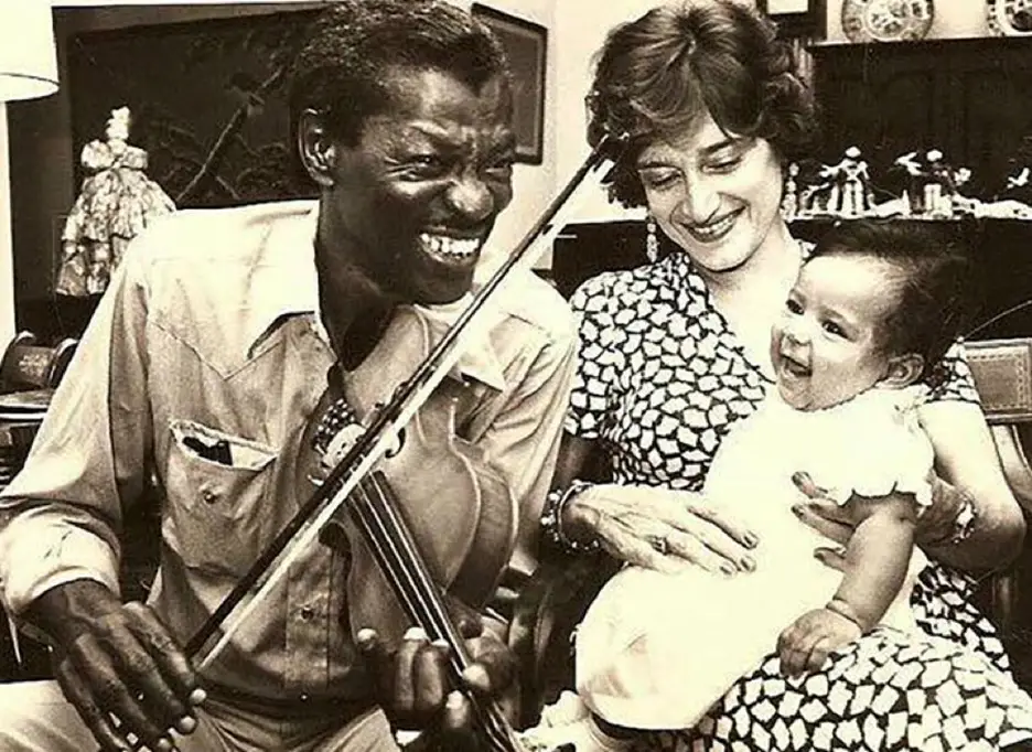 Photo of Clarence Brown playing violinto woman and baby - Image source: https://www.nola.com/news/communities/st_tammany/gatemouth-brown-memorialized-on-the-road-he-traveled-in-the-town-where-he-lived/article_f277260e-d927-11eb-819c-df6acd4e3d1d.html