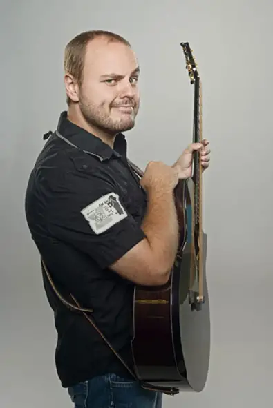 Andy McKee holding acoustic guitar - https://www.premierguitar.com/artists/guitarists/andy-mckee