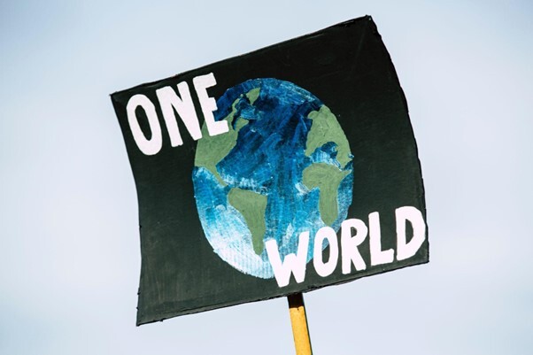 Banner saying one world on a picture of the world - Source: Pexels