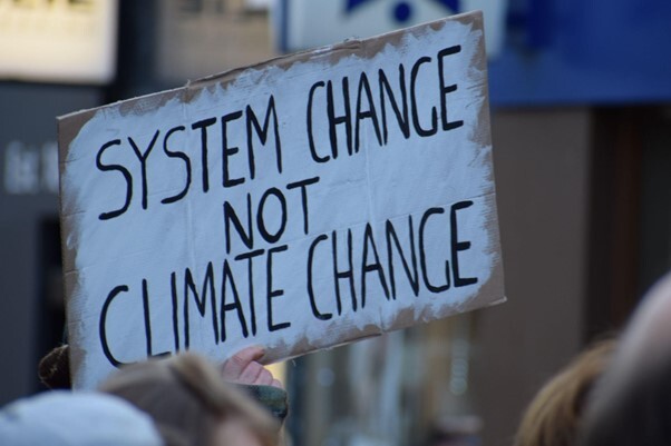 Banner saying - System Change not Climate Change - Source: Unsplash