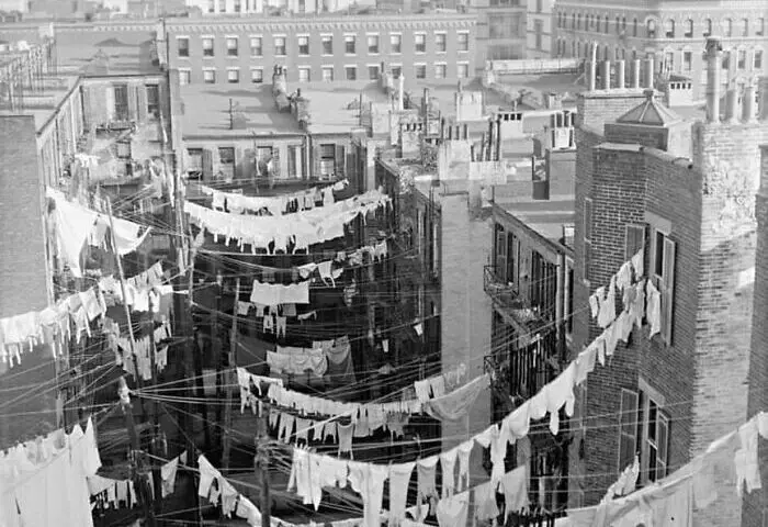 photo of laundry hanging between tenement buildings in New York